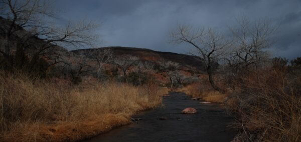 A winding stream flows through a rocky landscape