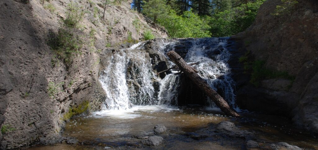 A serene waterfall cascades down rocky terrain